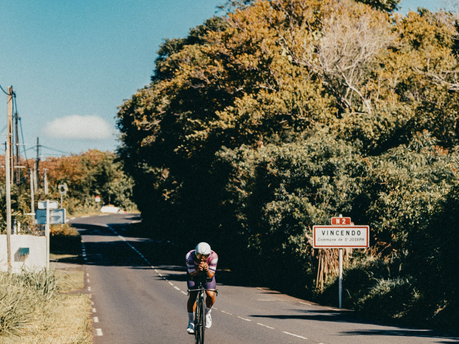 Un cycliste seul sur la route, à l'entrée de Vincendo