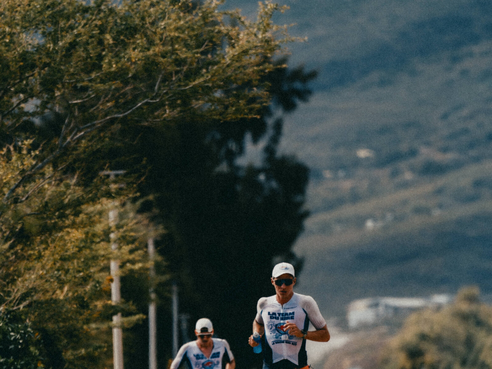 Coureurs sur la route, les montagnes en fond