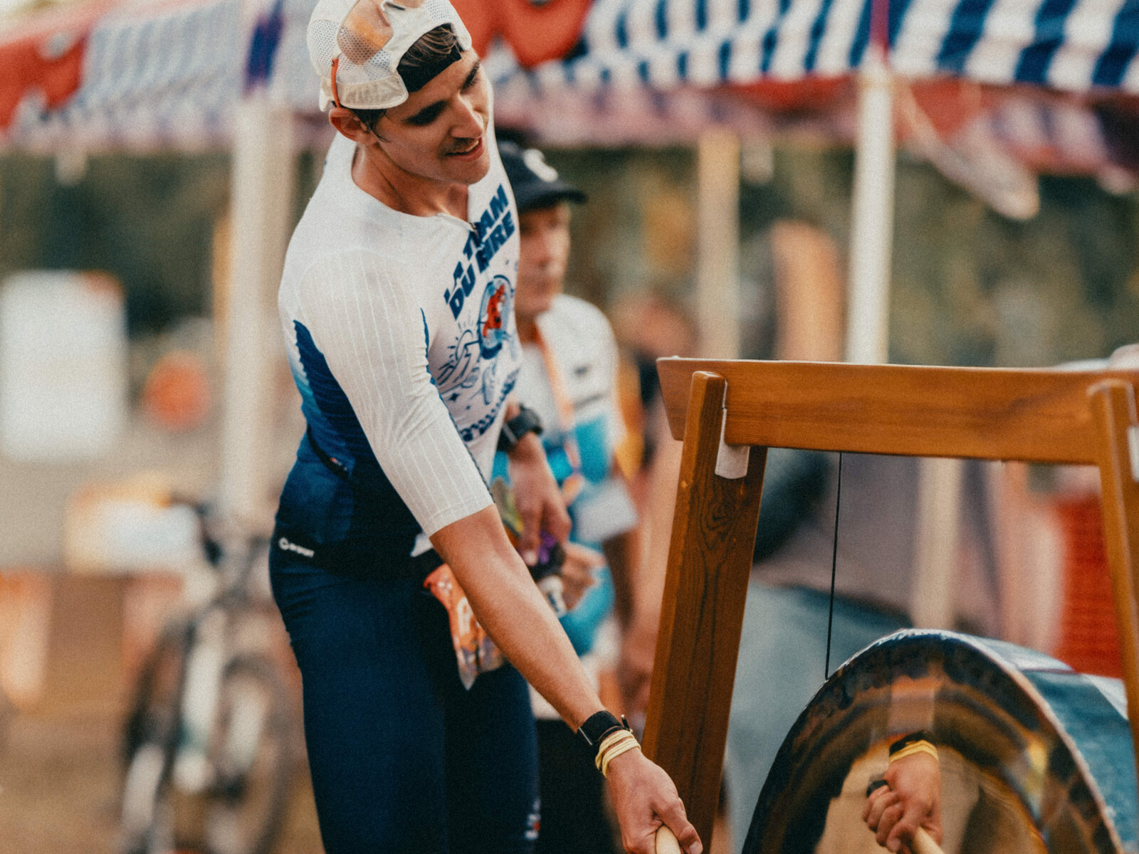 Un finisher frappe le gong sur la ligne d'arrivée